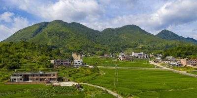 dalkey island aerial 日出时分，橙红色朝霞映照达尔基岛北侧草地，海面波光粼粼，无人机低角度侧拍